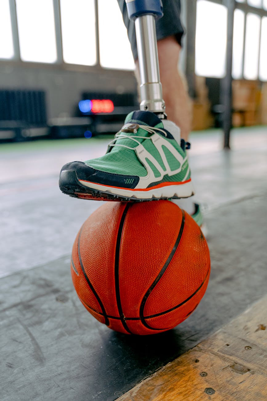 person holding prosthetic leg on basketball